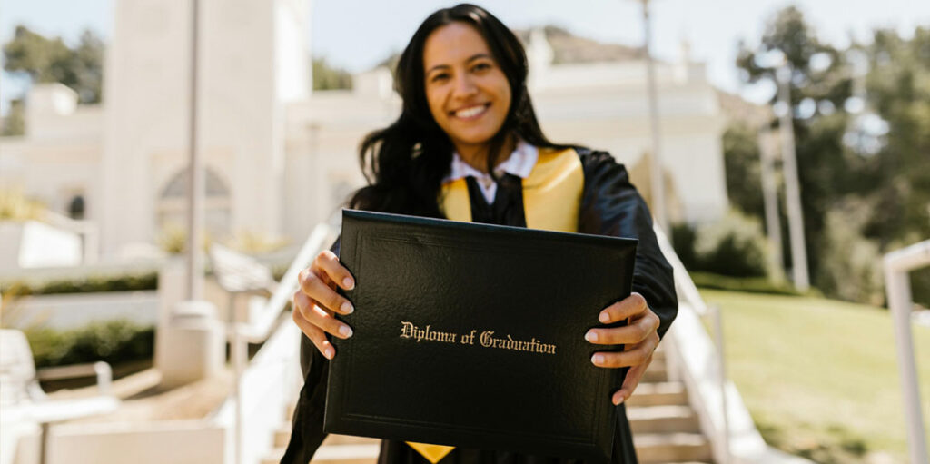 Jeune femme souriante tenant son diplôme ou sa certification coach de vie