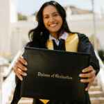 Jeune femme souriante tenant son diplôme ou sa certification coach de vie